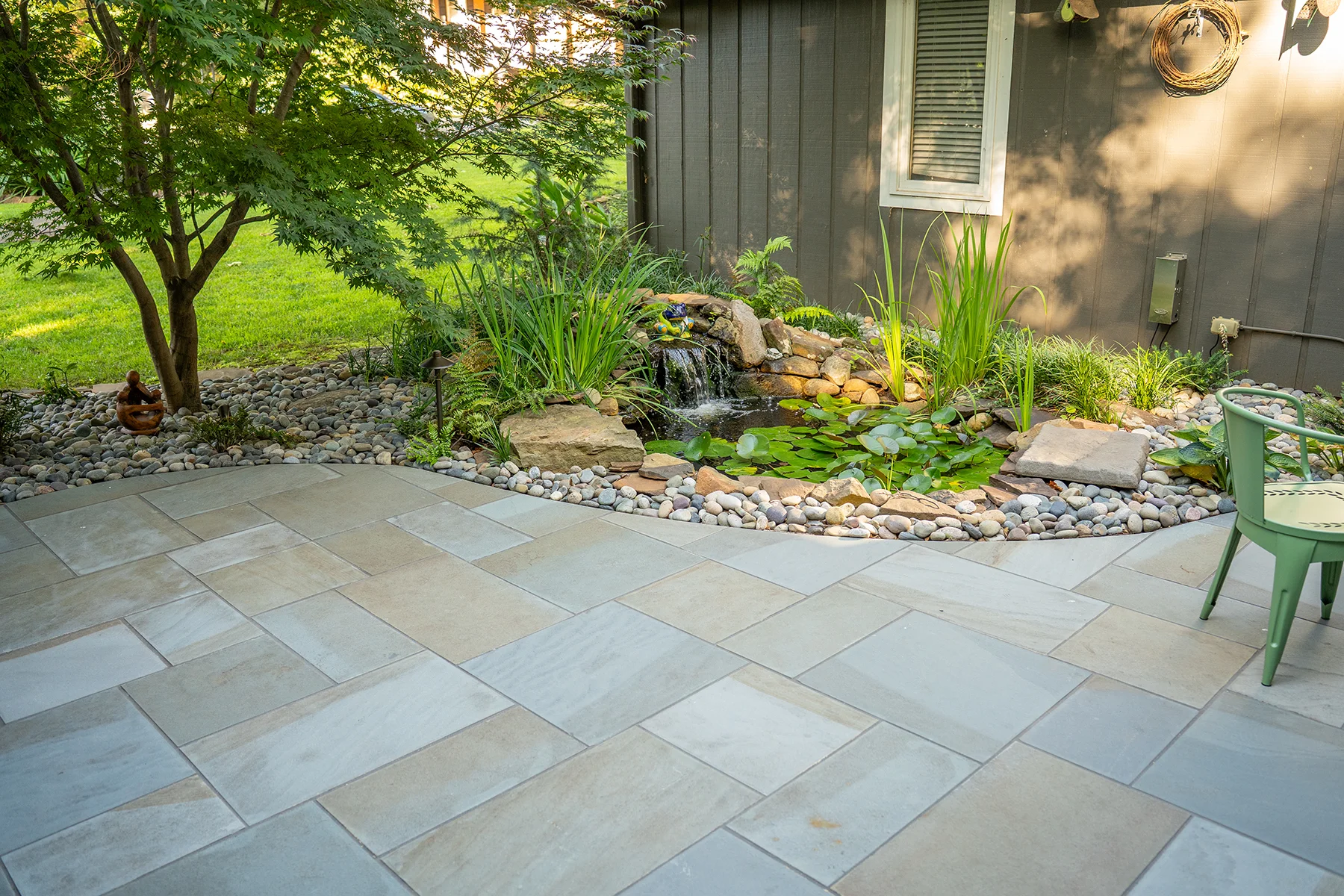 Courtyard patio landscape refresh in Greenville, SC featuring thermal bluestone, repaired water feature, and custom plantings