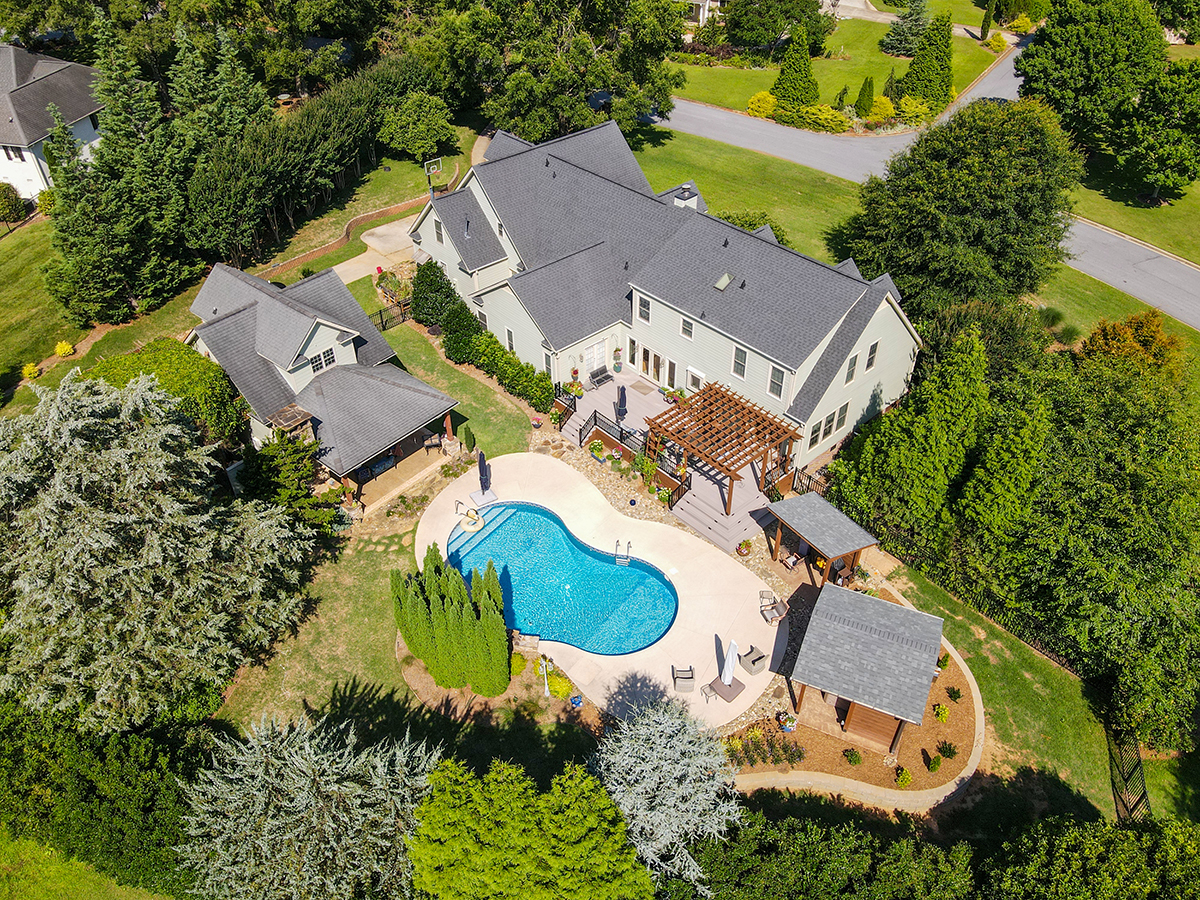 Aerial view of completed outdoor living renovation in Greenville, SC featuring pergola, covered kitchen, and stamped concrete pads