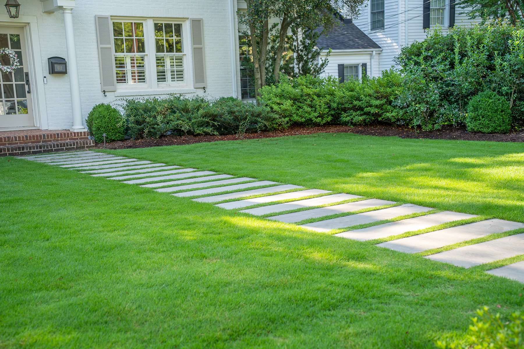 Stone paver walkway and green lawn in phased landscape design project, Greenville, SC