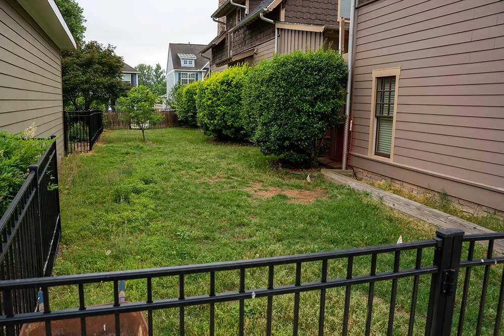 Narrow side yard between two homes before landscaping, a starting point for design build landscaping in Greenville, SC