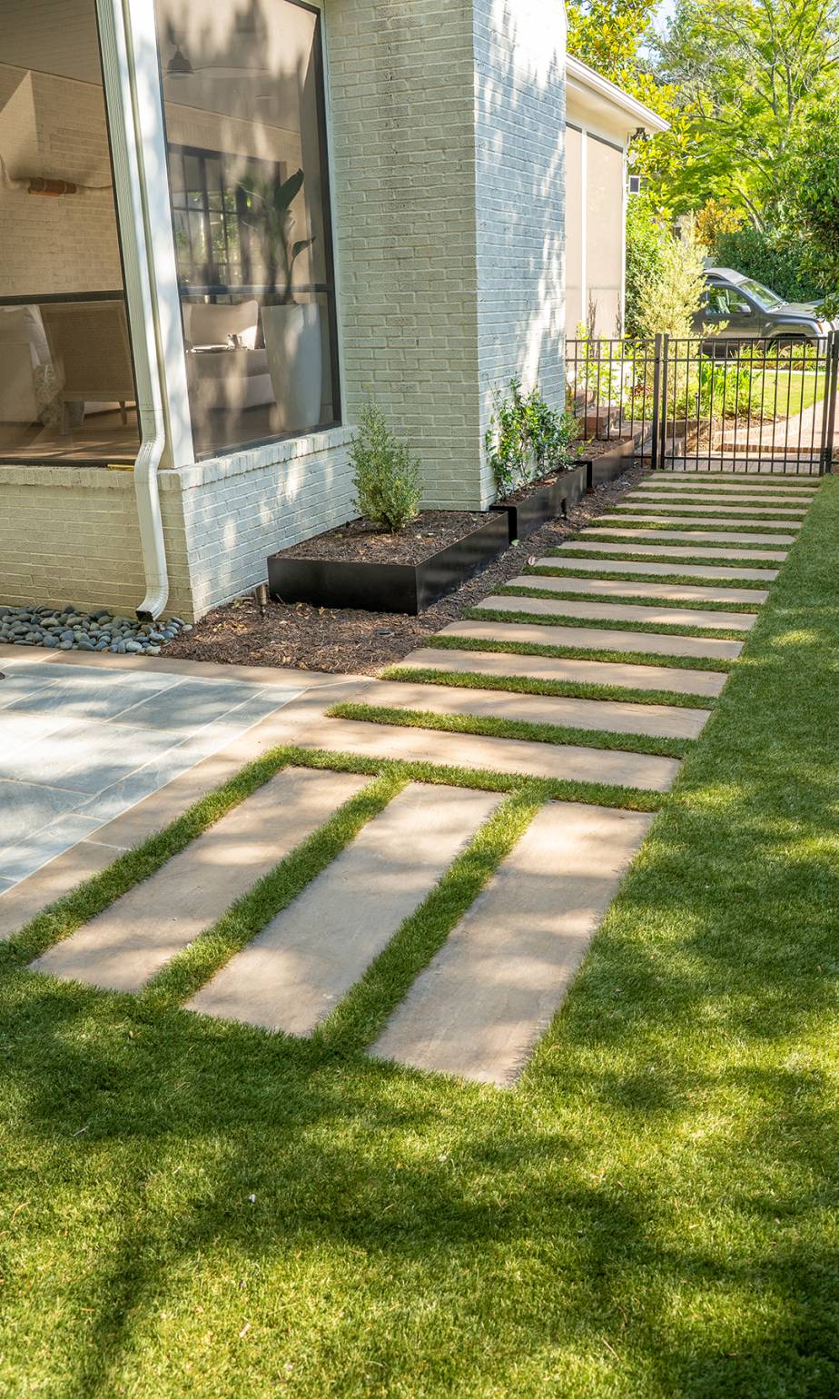 Landscape projects Greenville SC featuring modern stepping stone pathway with grass joints and clean-lined planters for refined outdoor access